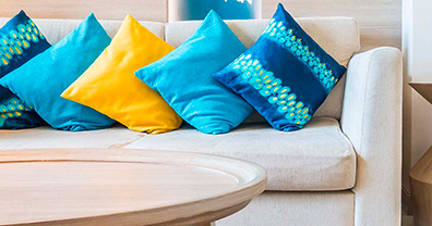 Sofá em cor neutra e almofadas vibrantes